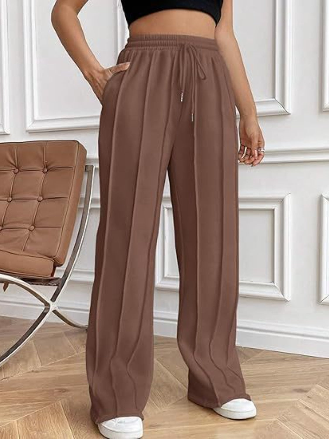 Brown pleated wide-leg lounge trousers with drawstring waist and pockets.