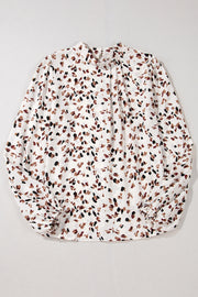 White high-neck blouse with abstract print and tie detail.