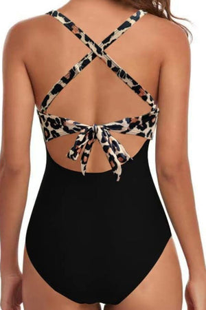 Black one-piece swimsuit with leopard print crisscross halter straps and back tie detail