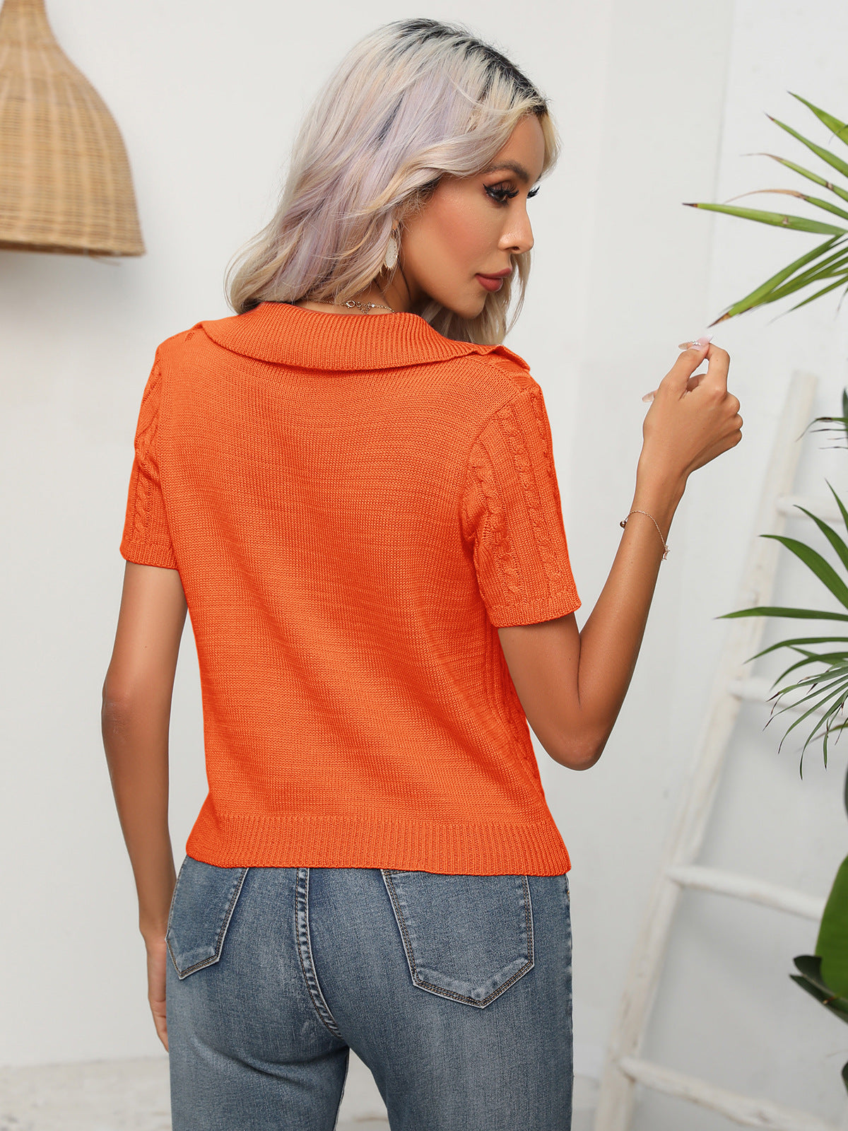 Orange cable knit polo top with short sleeves and a collared neckline.