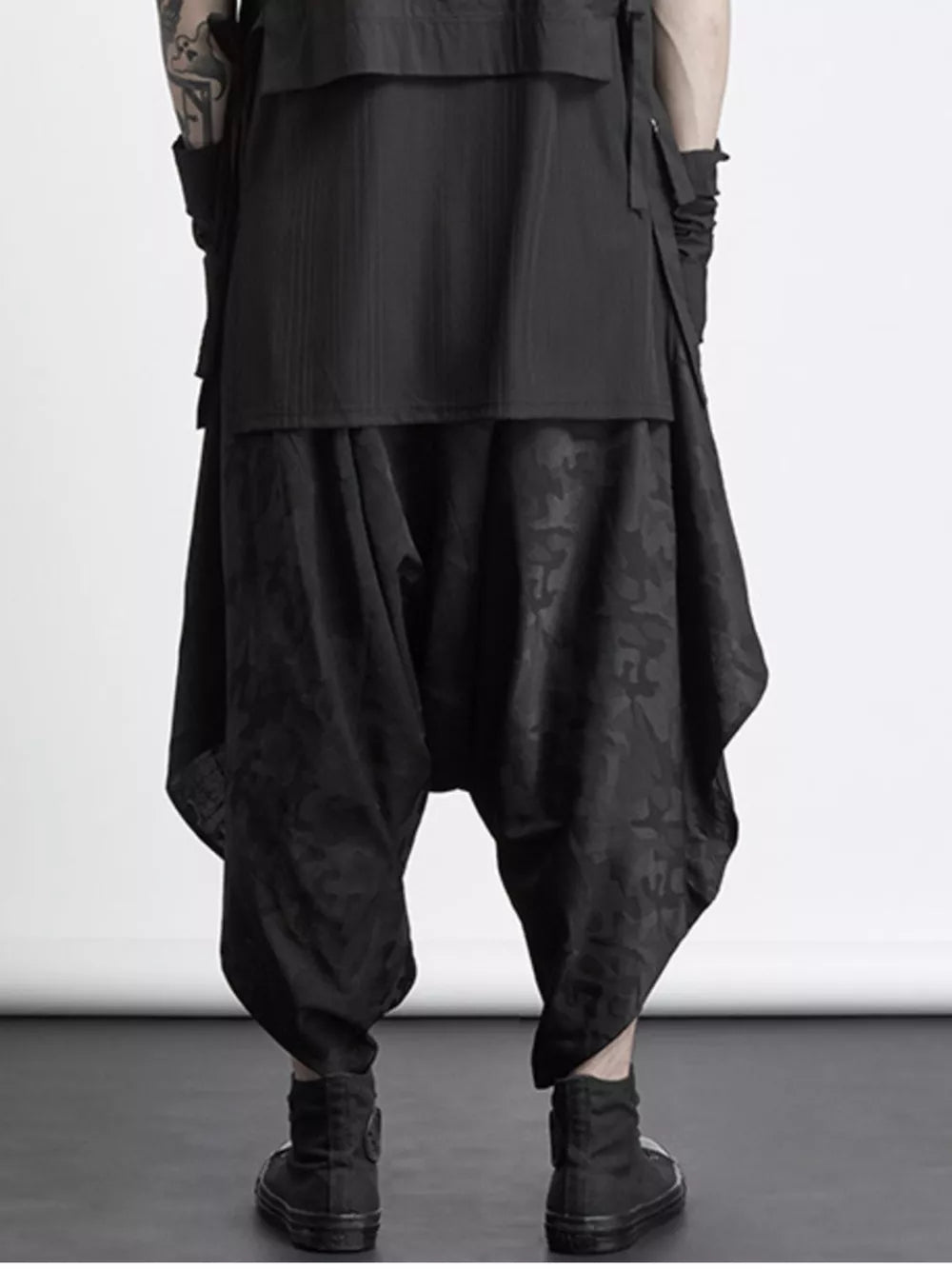 Black avant-garde harem sweatpants with an all-over tonal pattern and layered design.