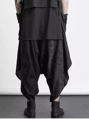 Black avant-garde harem sweatpants with an all-over tonal pattern and layered design.