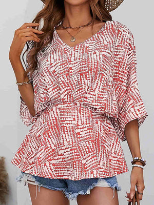 Abstract print cinched waist blouse with V-neck and short sleeves in scarlet.