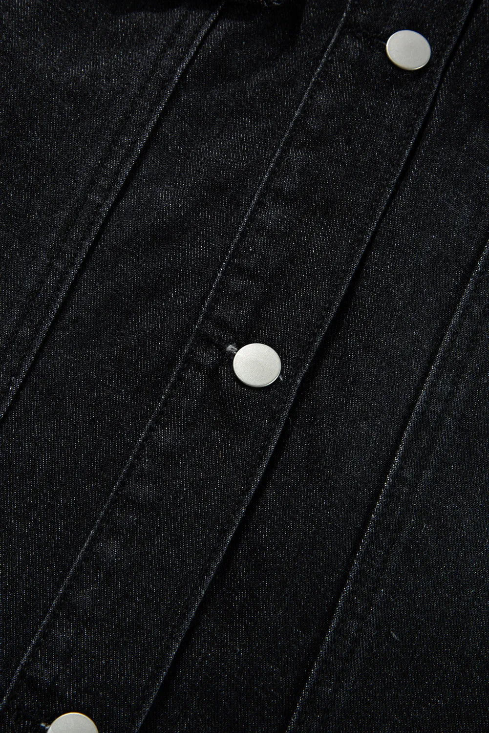 Black denim trucker jacket with silver buttons and detailed stitching.