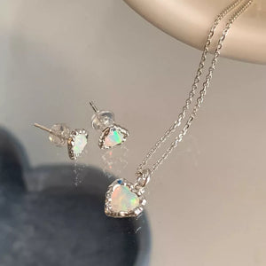 Charming heart pendant necklace and stud earrings set in silver with opal accents.