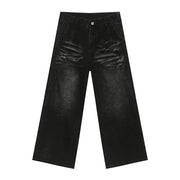 Faded black denim palazzo trousers with a wide leg and distressed detailing.