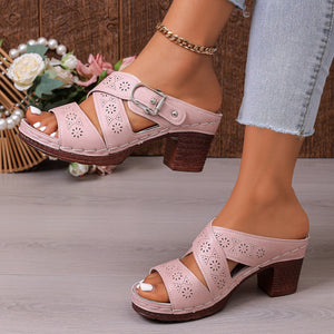 Pink laser-cut criss-cross block heel sandals with buckle detail.