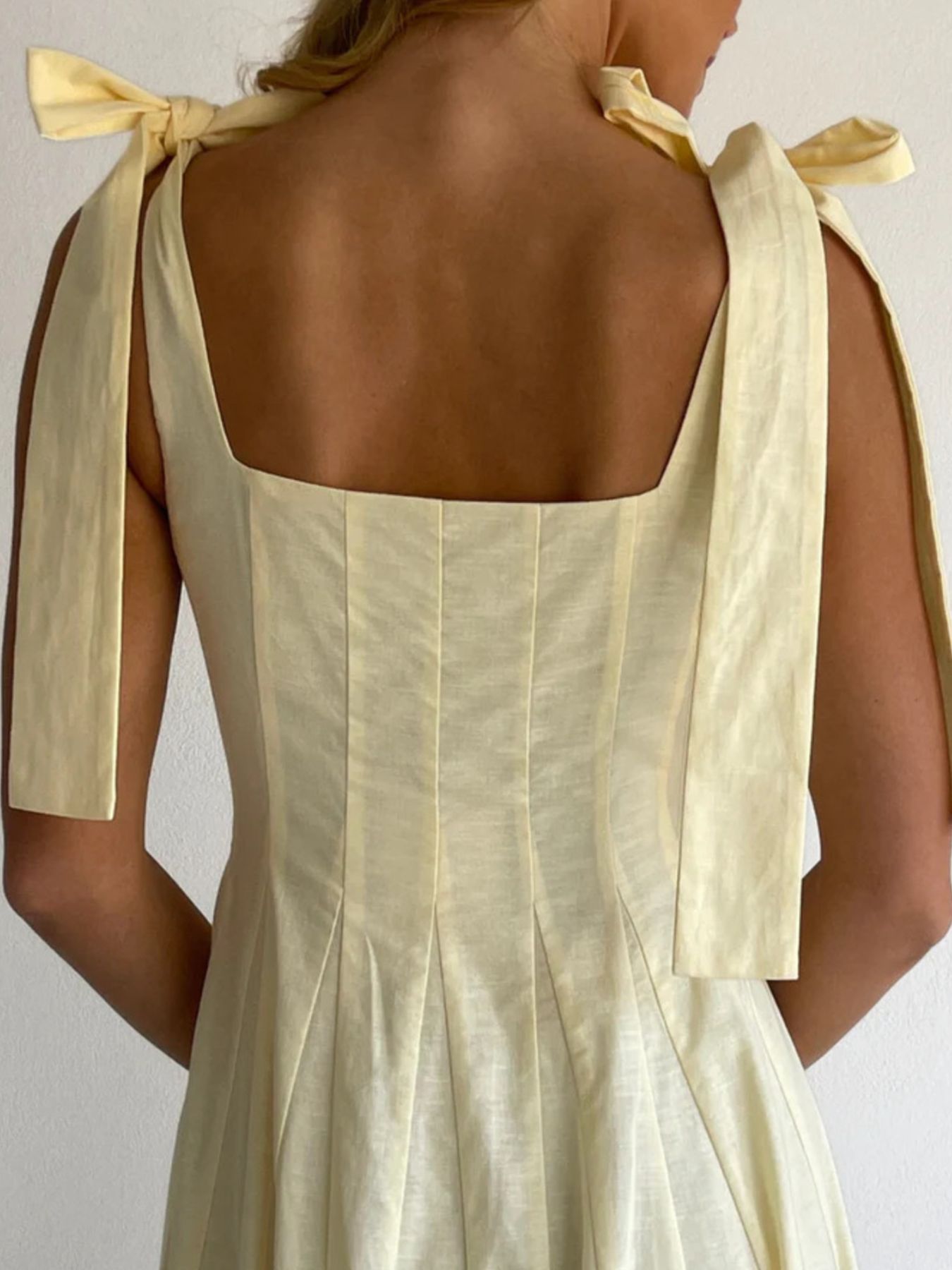 Yellow maxi dress with bow-tie shoulder straps and square neckline.