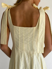 Yellow maxi dress with bow-tie shoulder straps and square neckline.