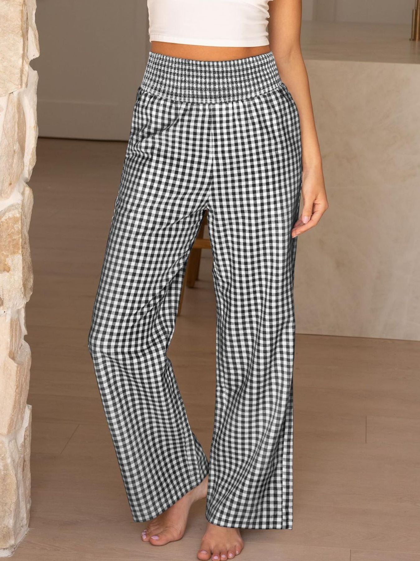 Smocked high-waist wide-leg pants in black and white gingham pattern.
