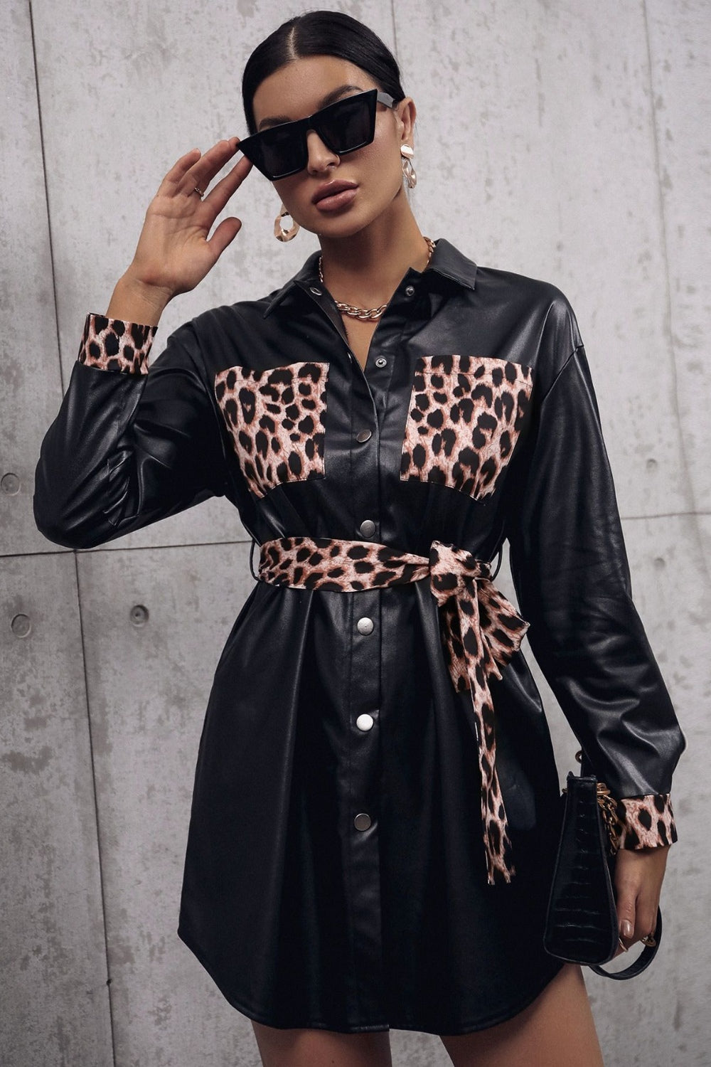 Black faux leather shirt dress with leopard print pockets, cuffs, and belt