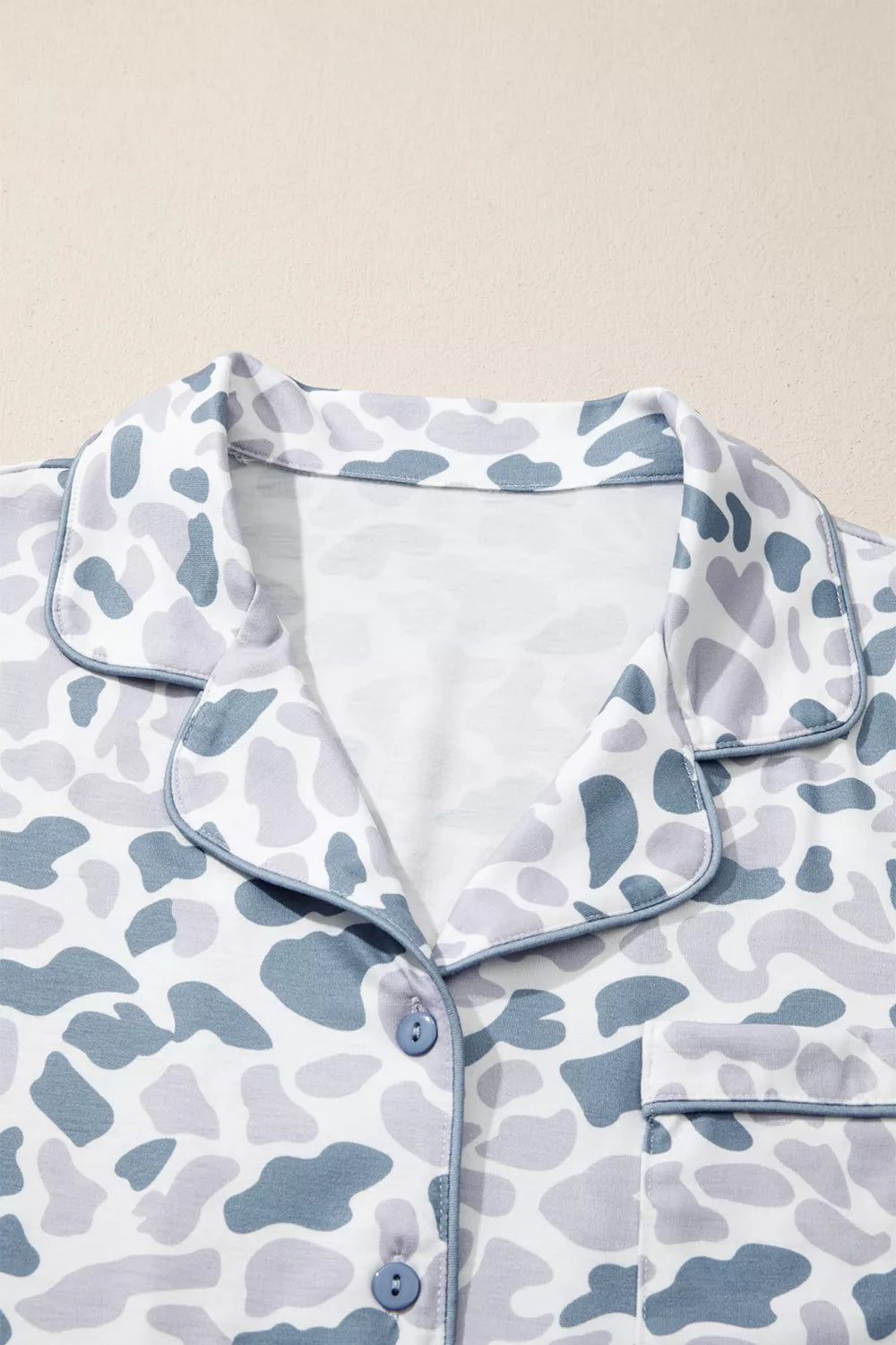Blue camouflage print button-down pajama top with piped trim and chest pocket.