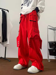 Men's relaxed-fit red cargo pants with multiple functional pockets and button details.