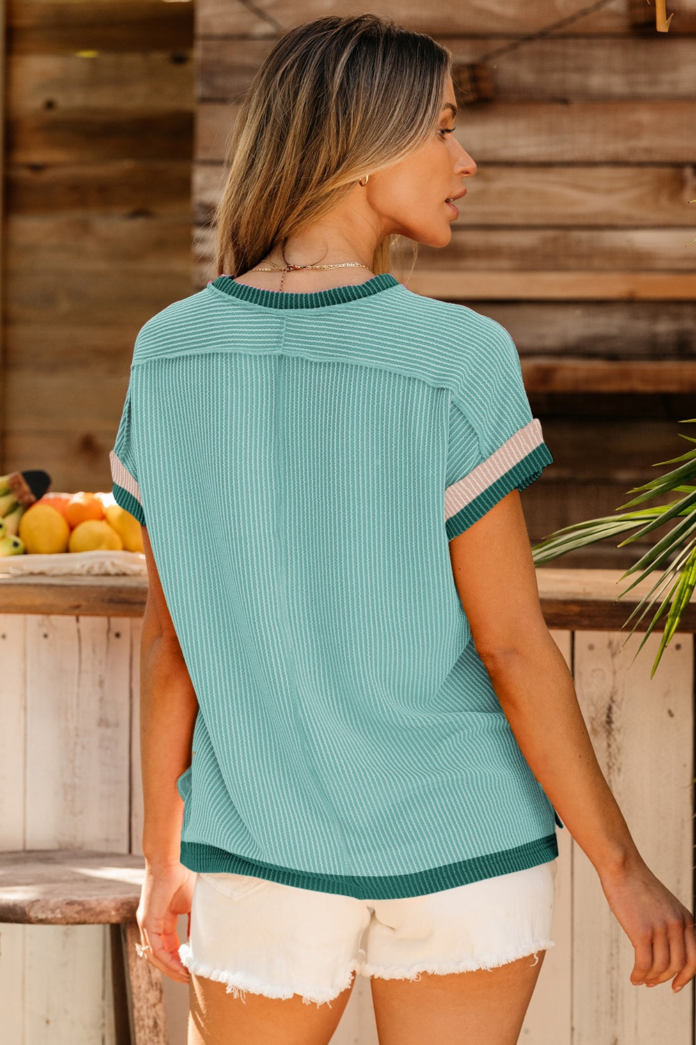 Ribbed colorblock tee in teal with pink and green trim on sleeves and hem.