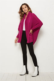 Cocoon knit cardigan with shawl collar and batwing sleeves in deep purple acrylic.