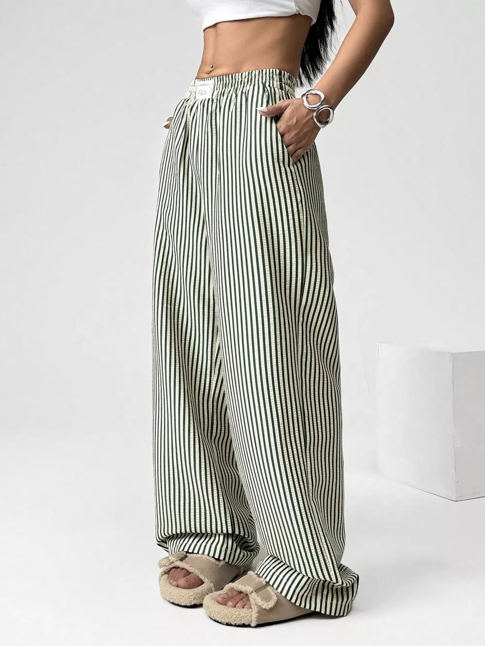 Navy striped high-waisted wide-leg pants with drawstring detail.
