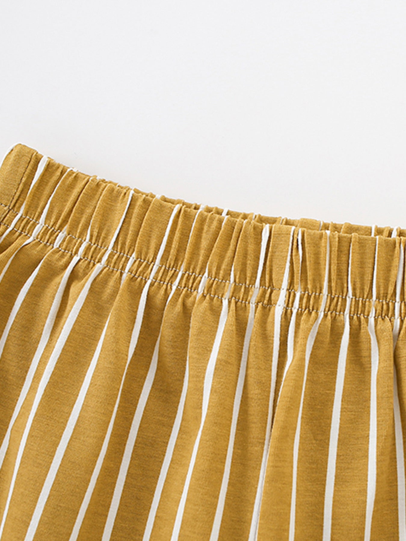 Toddler shorts with elastic waistband and white vertical stripes on apricot cotton fabric.