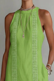 Lime green midi dress with white lace trim and pockets, sleeveless halter neck.