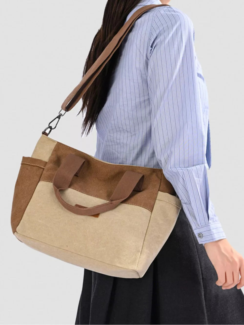 Multi-pocket canvas travel bag in taupe with adjustable strap and top handles.