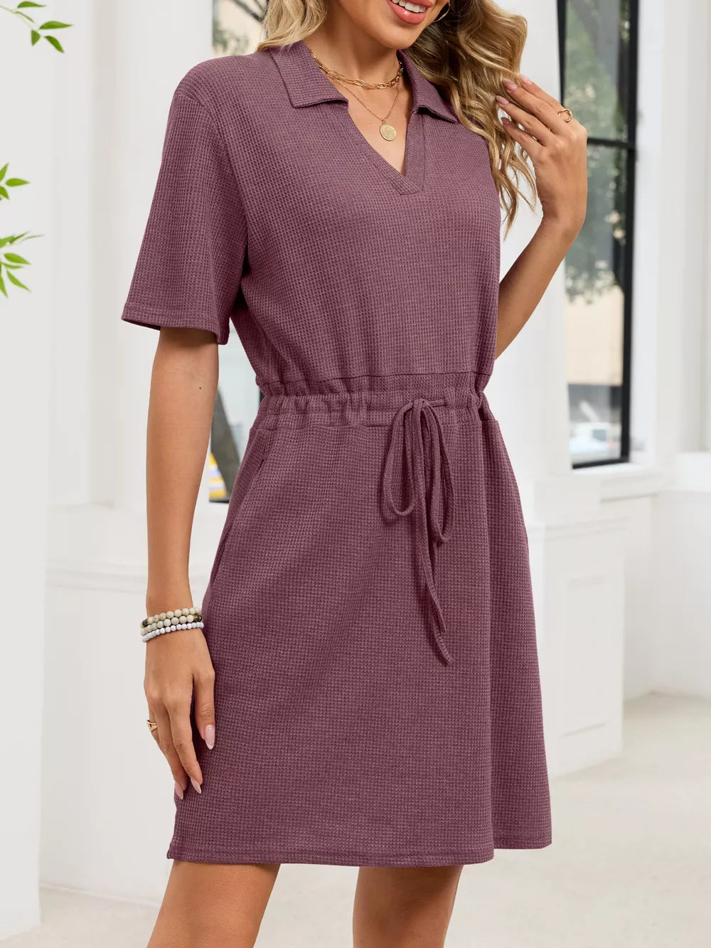 Textured polo dress in pink with short sleeves, V-neck, and adjustable drawstring waist.