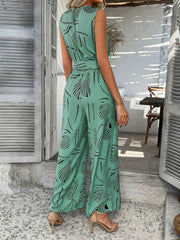 Turquoise abstract print wide-leg jumpsuit with a belted waist and sleeveless design.