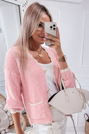 Blush pink bouclé cardigan with scalloped trim, gold buttons, and pocket details.