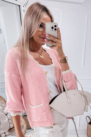 Blush pink bouclé cardigan with scalloped trim, gold buttons, and pocket details.