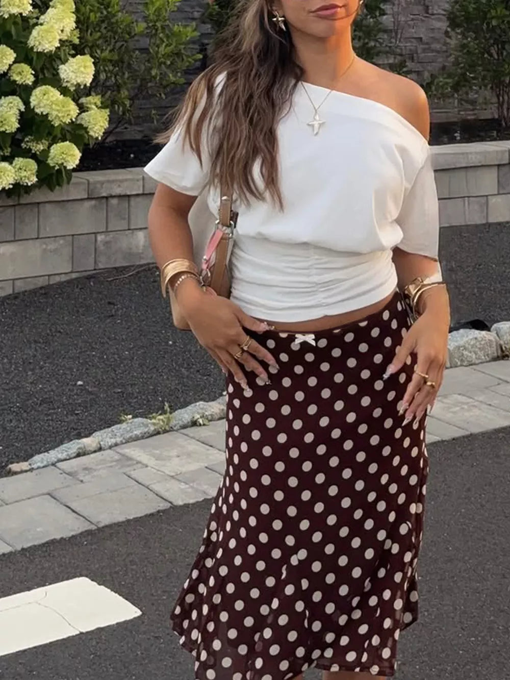 Dark brown polka dot A-line skirt with a bow detail at the waist.
