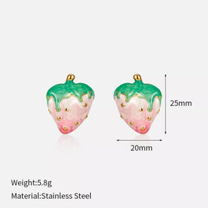 Playful strawberry charm earrings with green tops and pink bodies, featuring gold details.