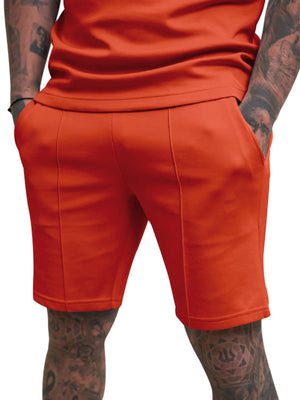 Men's orange red chino shorts with drawstring and front seam detail.