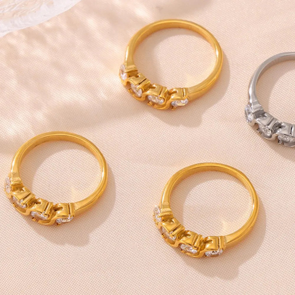 Gold and silver band rings with clear cubic zirconia stones, casual chic style.