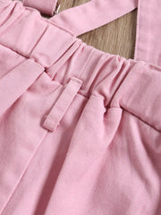 Pink cotton distressed overalls with elastic waist and adjustable straps.