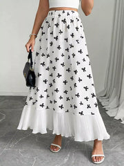 White maxi skirt with black bow print and ruffled hem.