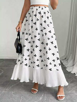 White maxi skirt with black bow print and ruffled hem.