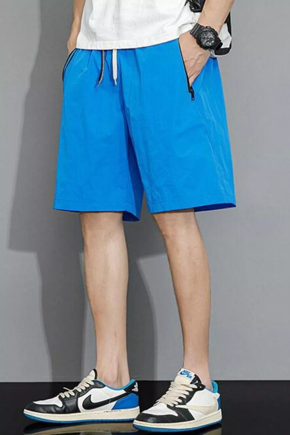 Sky blue quick-dry men's shorts with drawstring and zippered pockets.