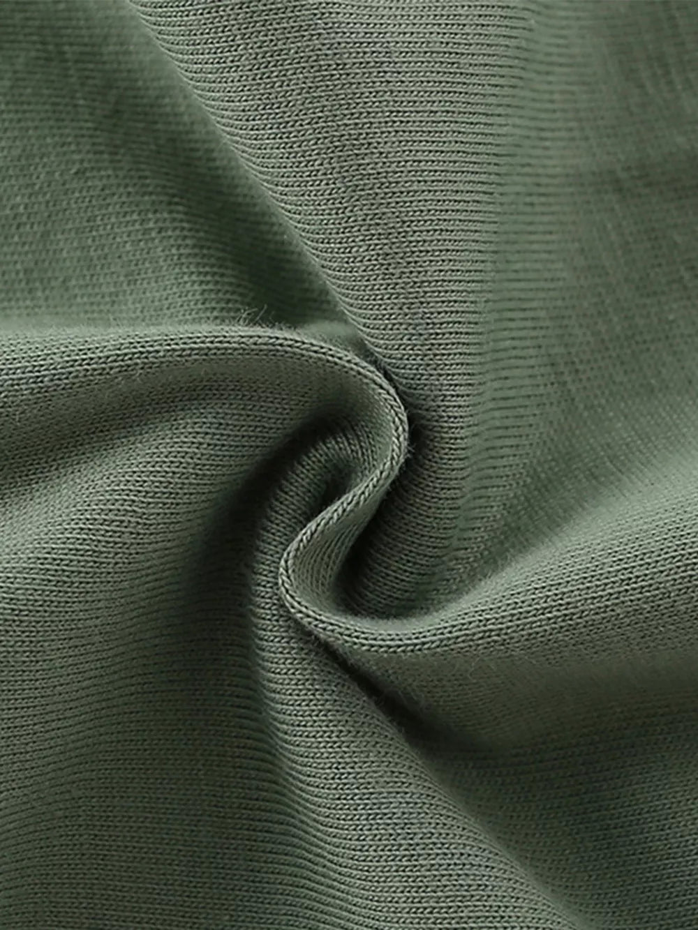 Green cotton knit fabric detail, showing texture and weave.