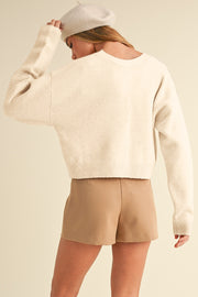 Ivory bouclé knit cardigan with crew neck and relaxed fit.