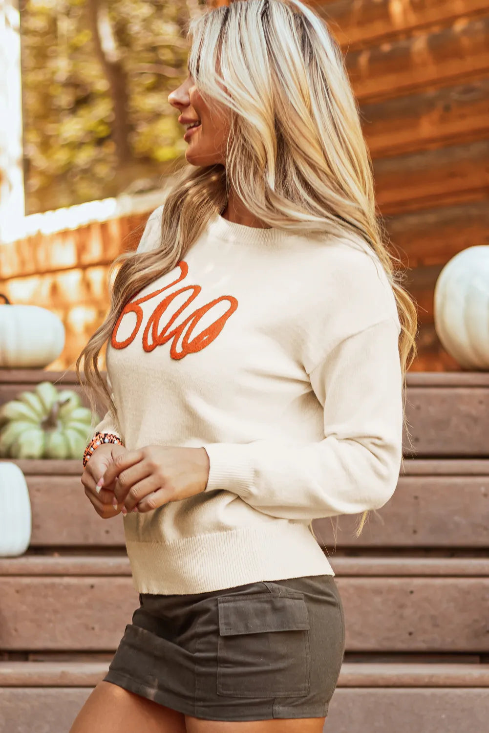 Ivory crewneck sweater with orange "Boo" appliqué detail.