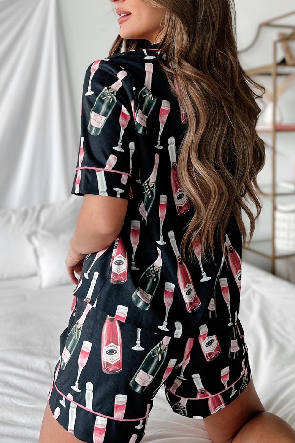 Black silk pajama set with champagne bottle and glass print, pink piping.