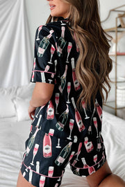 Black silk pajama set with champagne bottle and glass print, pink piping.
