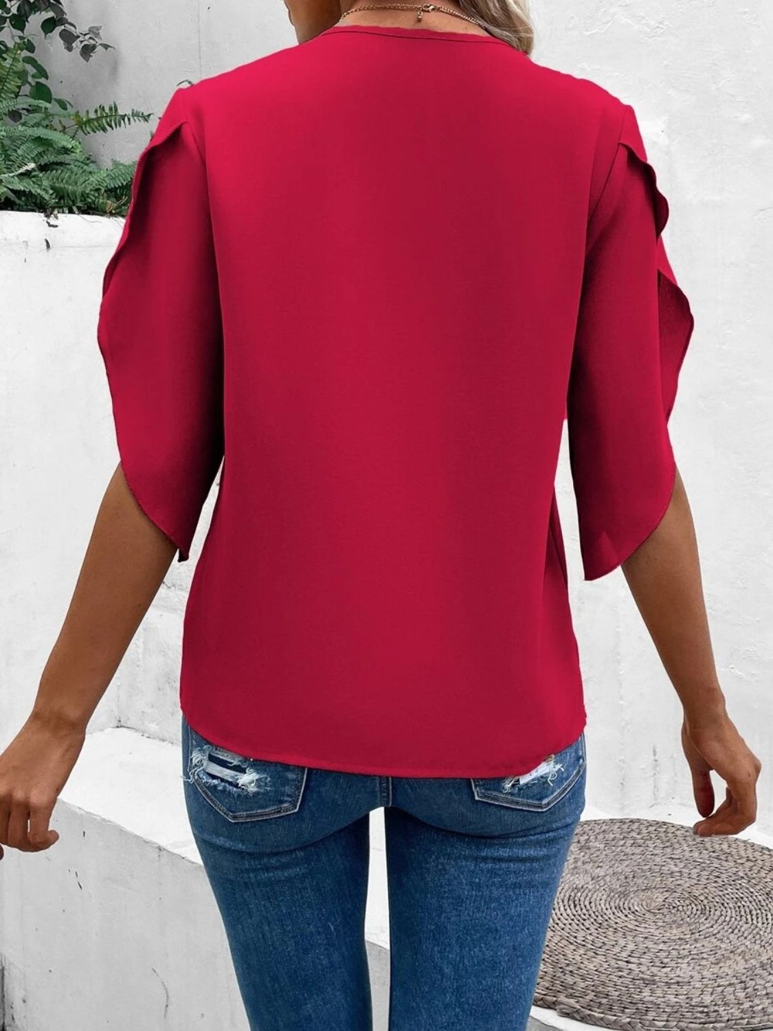 Deep red blouse with scalloped lace trimmed flutter sleeves and a V-neck.