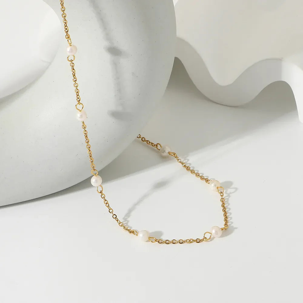 Delicate gold chain necklace with scattered pearls