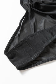 Black sheer mesh bodysuit detail with elasticized leg openings and stitched seams.