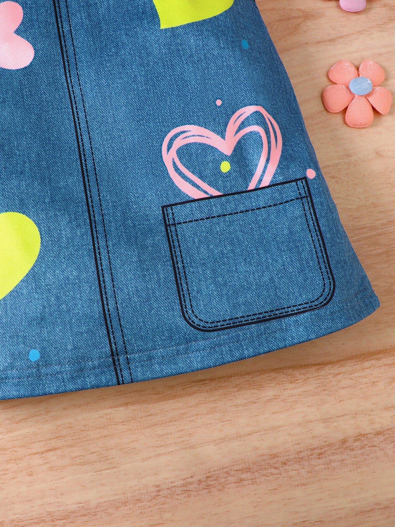 Baby dress with blue denim print, pink and yellow hearts, and a functional pocket.