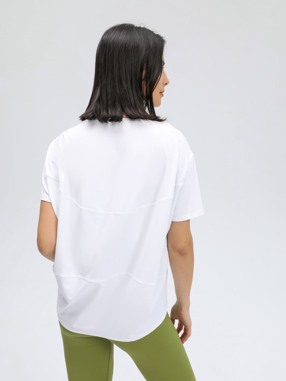 White relaxed fit performance tee with short sleeves and curved hem.