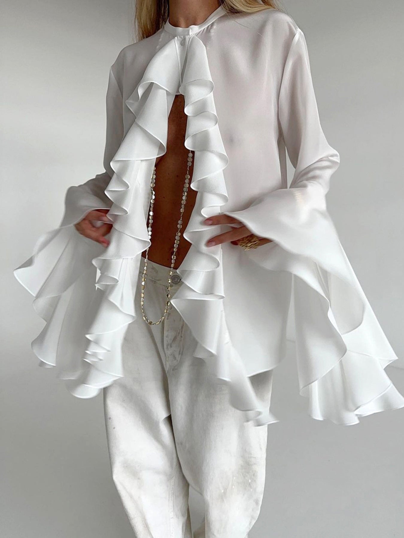 White ruffled flounce sleeve blouse with a buttoned neckline and airy fabric.