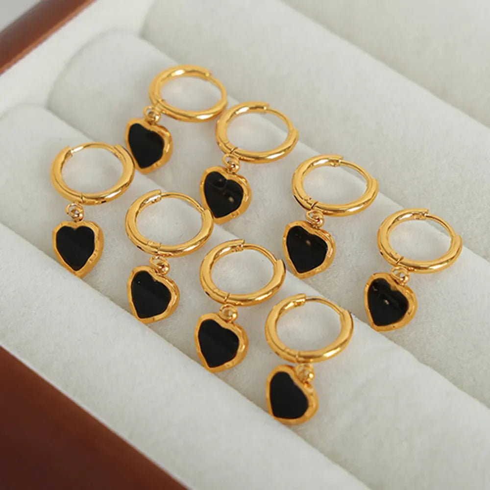 Gold hoop earrings with black enamel heart charms