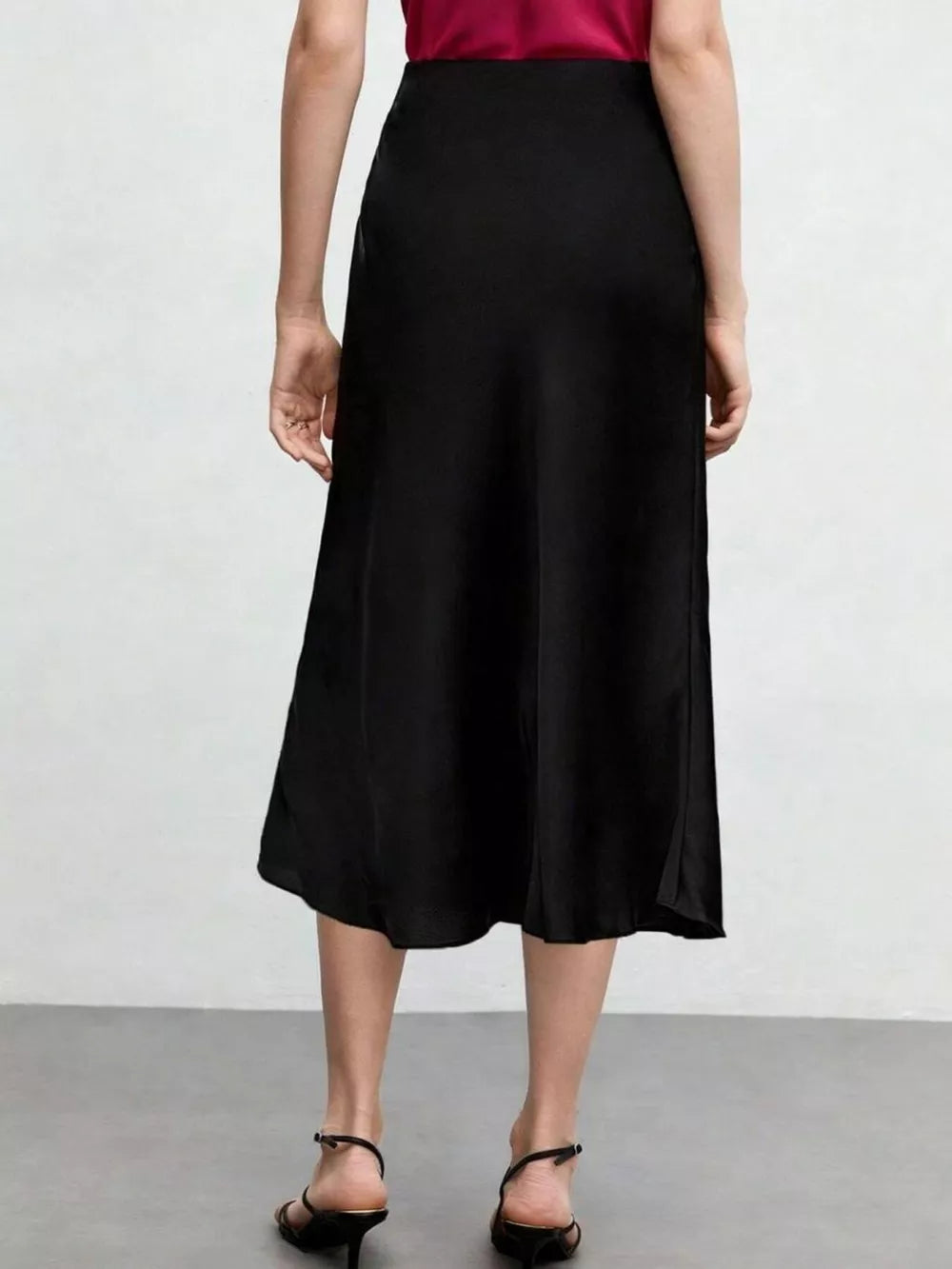 Black A-line midi skirt with a high waist and subtle side slit.