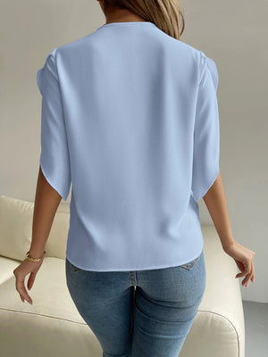 Light blue polyester blouse with cape sleeves and lace trim detail.