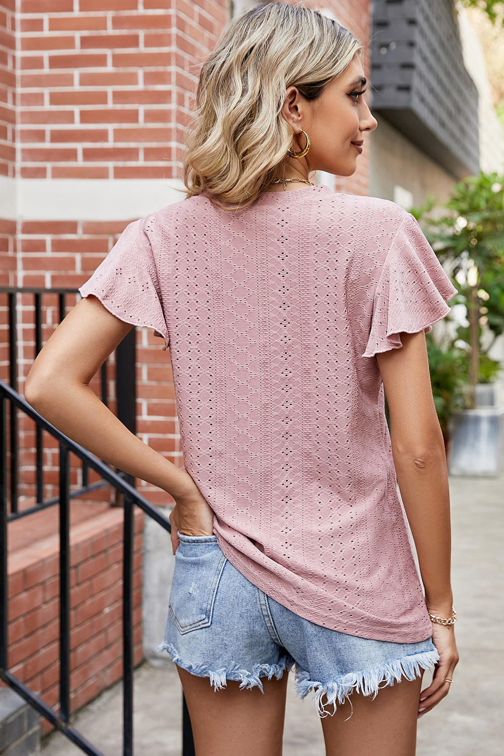 Flutter sleeve eyelet top in watermelon pink with a textured pattern.